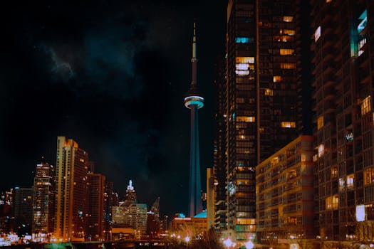 The CN Tower illuminated amidst Toronto's stunning night skyline, showcasing urban city life.