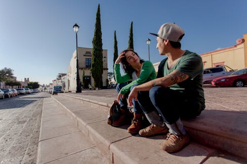 Photo of a Couple Sitting on Concrete Steps