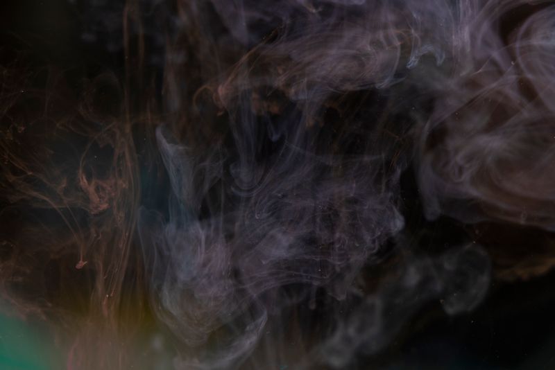 Abstract image of swirling smoke patterns against a dark background, creating a mysterious texture.