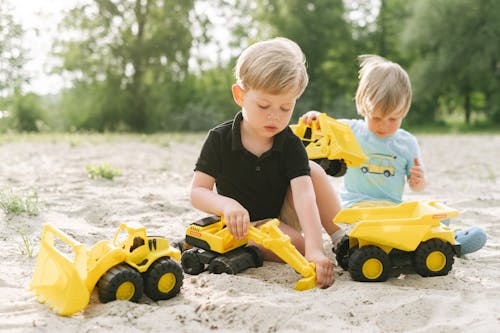 Free Photo of Siblings Playing with Toys on the Sand Stock Photo