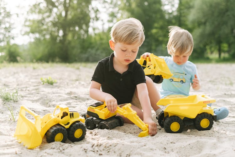 Photo Of Siblings Playing With Toys On The Sand