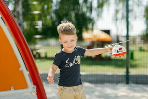 Photograph of a Kid Playing with a Helicopter Toy