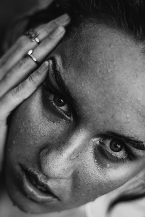 Grayscale Photo of Woman Holding Her Head 