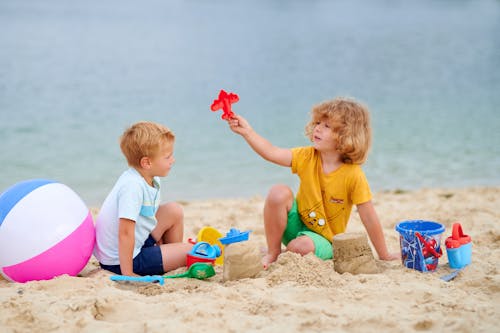 Photo of Boys Playing with Toys on the Sand