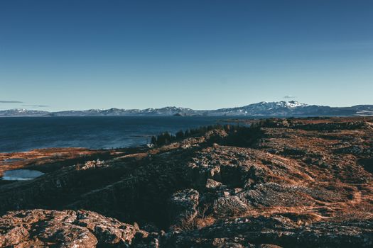 A breathtaking view of Icelandic mountains and a serene lake under a clear sky.