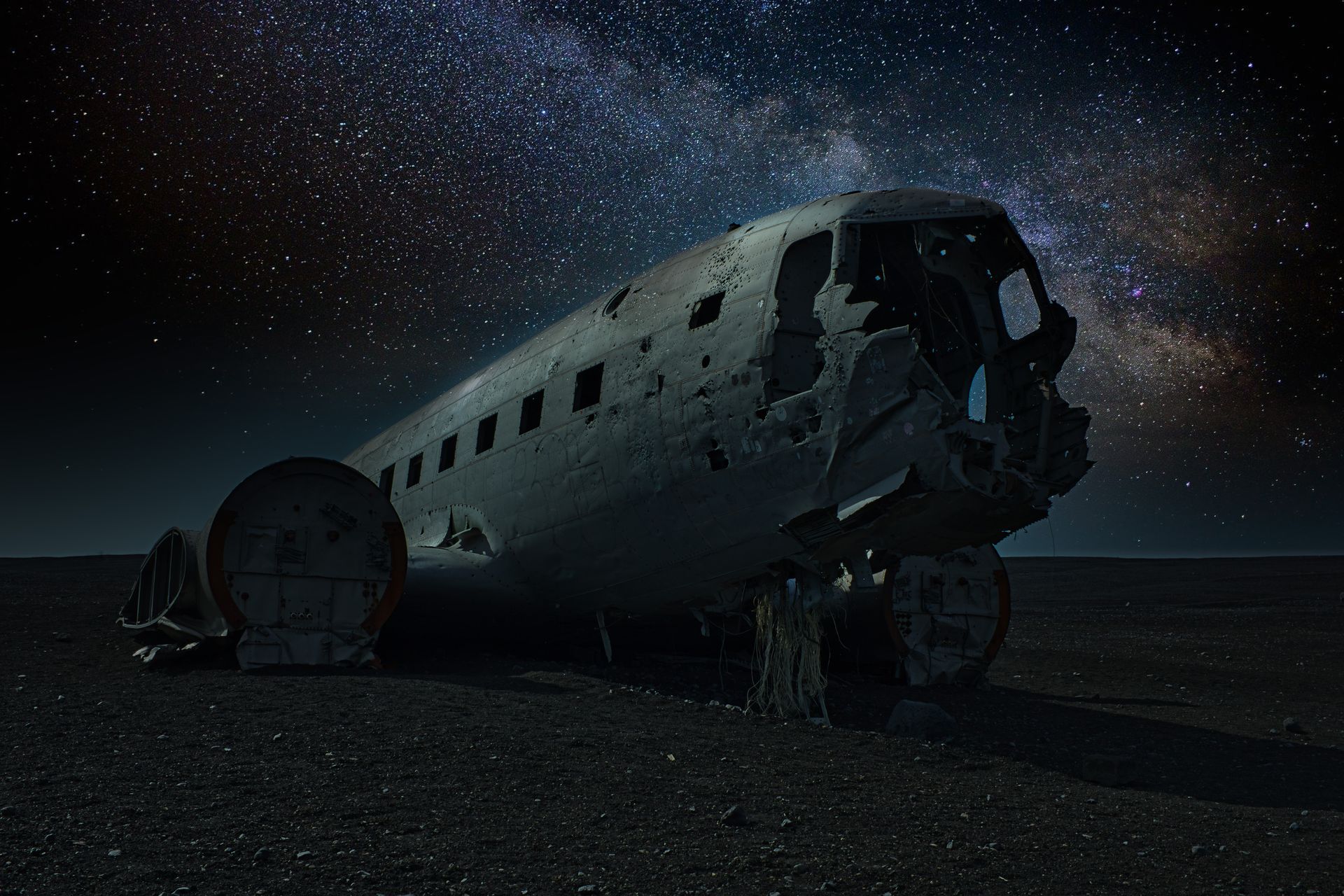 A haunting image of a crashed plane against Iceland's starry night sky.