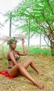 A Woman in Bikini Collecting Fire Woods
