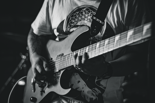 Free Monochrome image of a guitarist playing an electric guitar passionately indoors. Stock Photo