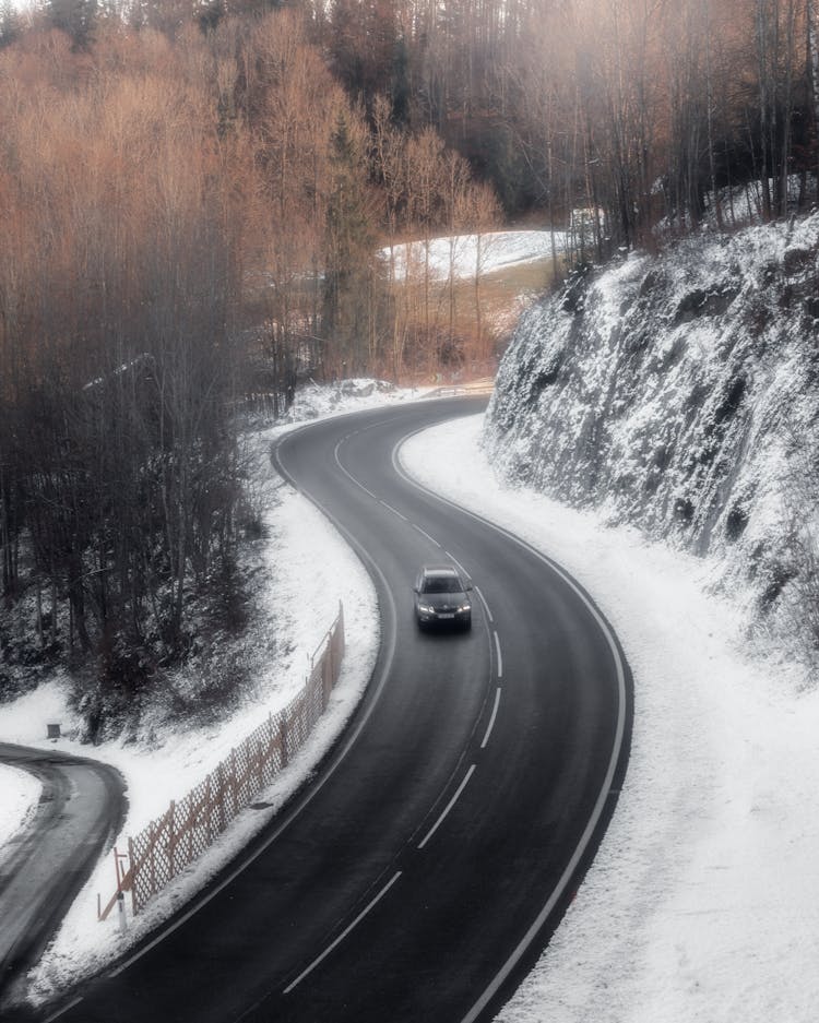 A Car Traveling On The Mountain Road