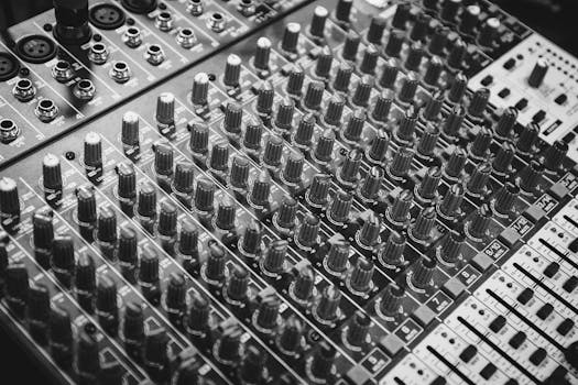 Detailed close-up of audio mixer knobs in monochrome, showcasing precision in musical equipment.