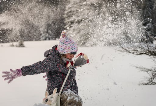 A child enjoying winter playtime, throwing snow in the air with a joyful expression and colorful winter attire.