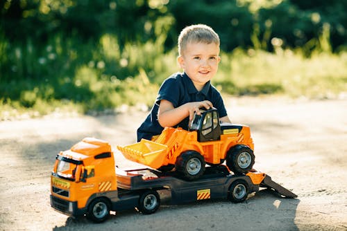 A Boy Playing with Toy Trucks