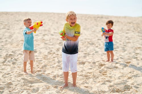Kids Playing Water Guns in the Beach