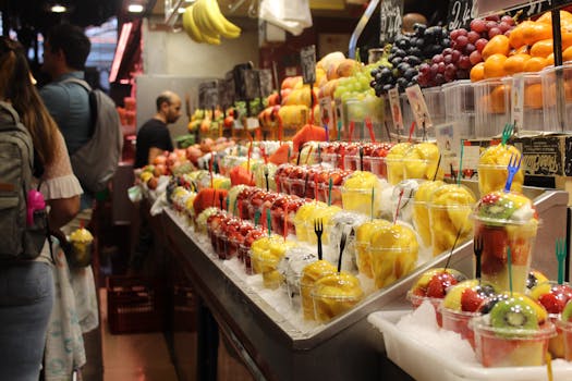 Colorful assortment of fresh fruits at a bustling Barcelona market showcasing local produce.