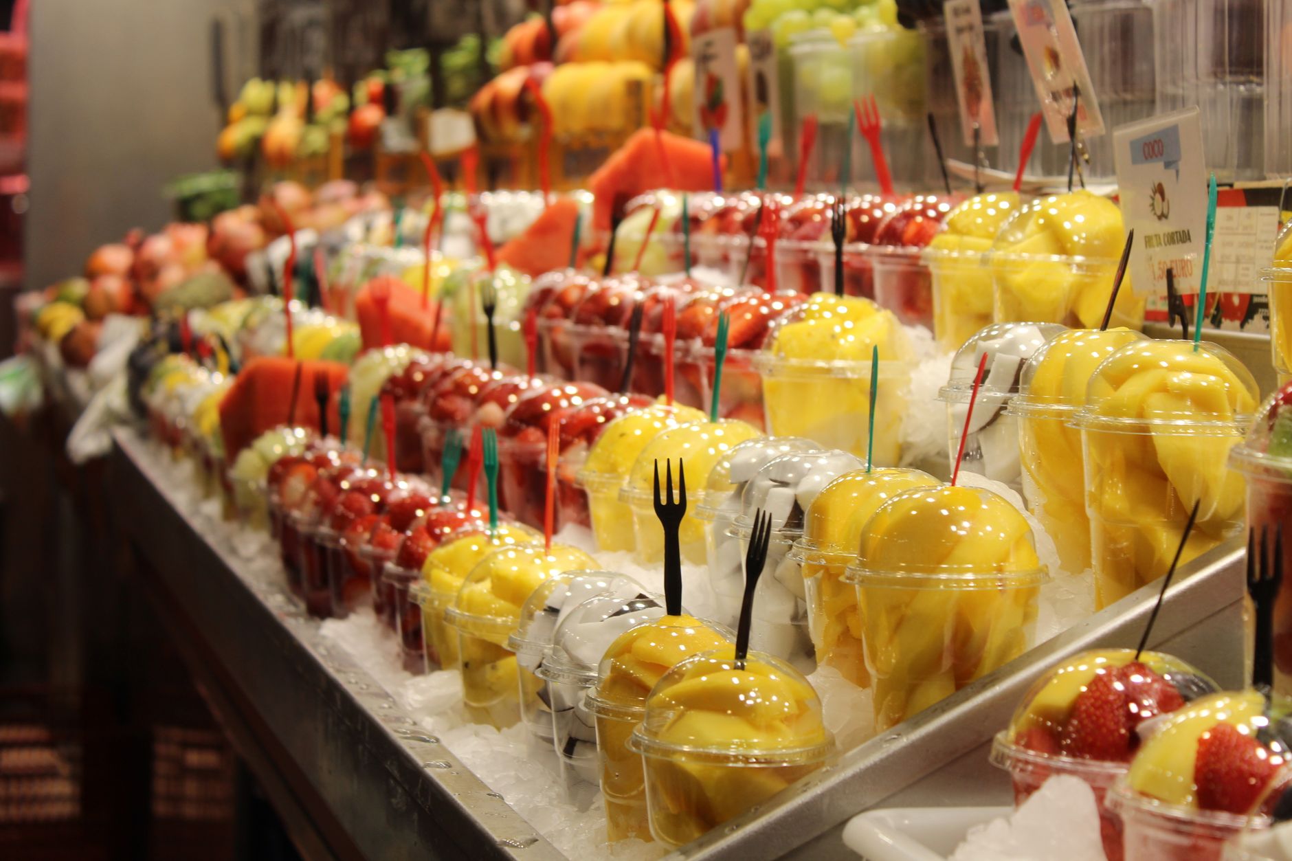 地中海飲食實用指南:購物清單與簡單料理技巧 Delicious fresh fruit cups displayed at a bustling market in Barcelona, Spain.