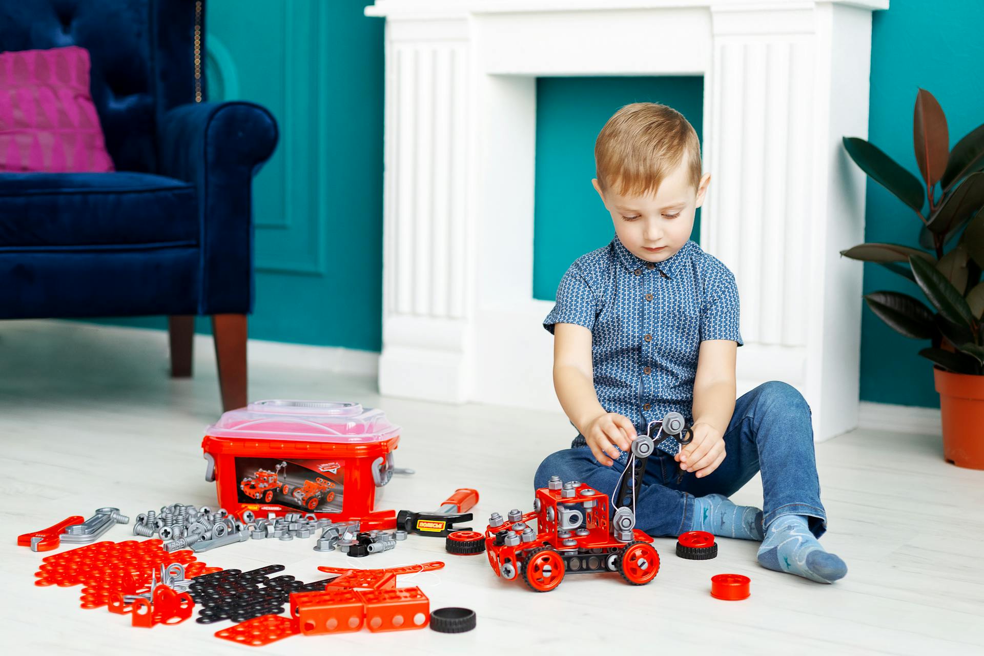 Young boy engaged in creative play with toy truck parts in a living room setting.
