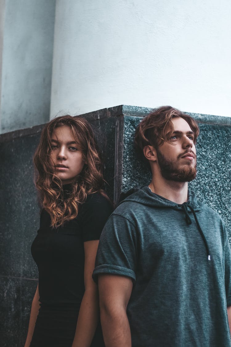 Woman In Black Shirt Standing Beside A Man Wearing T-Shirt Hoodie