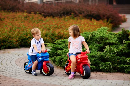 A Boy and a Girl Riding a Motorbike Toy