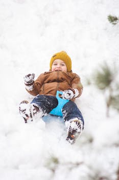 A happy child sledding on a snowy day, filled with joy and laughter.