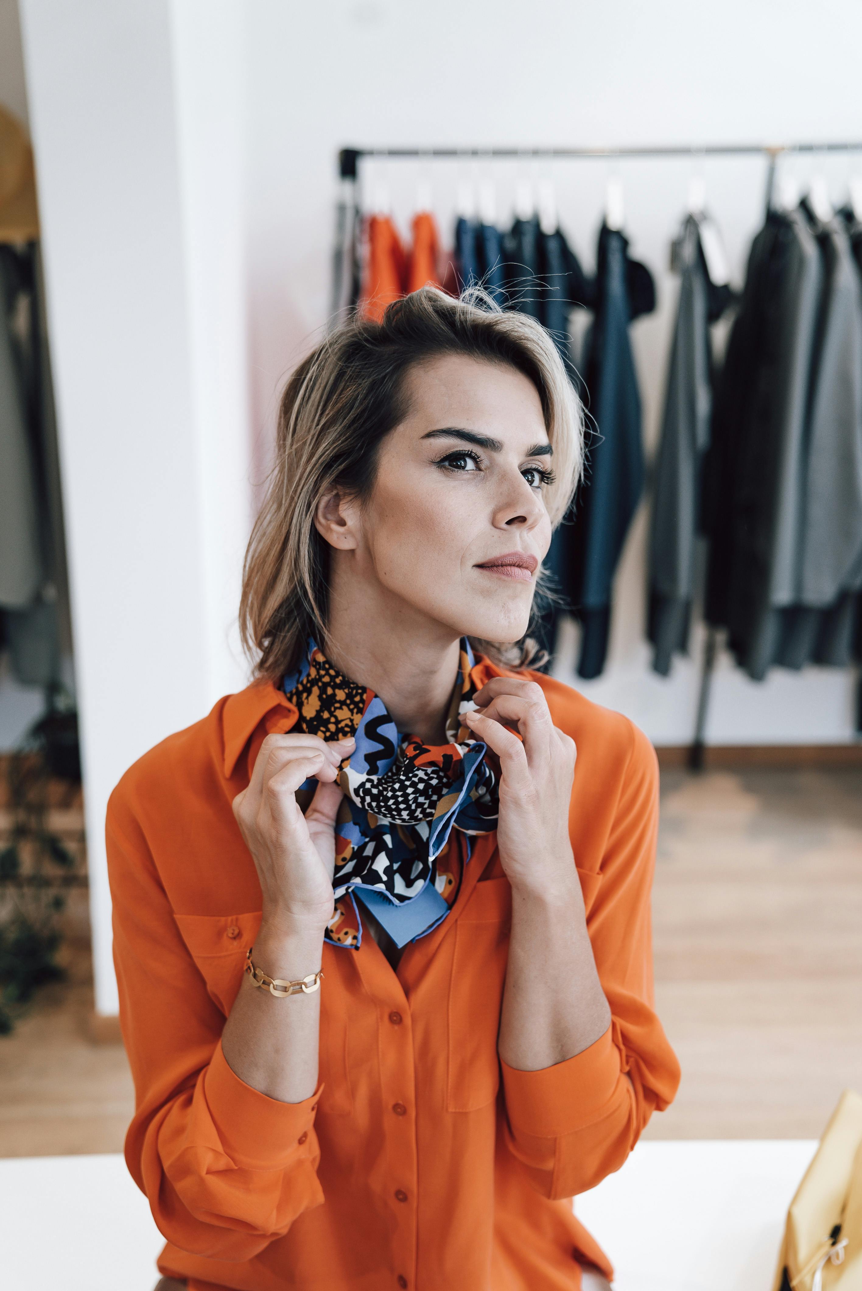 stylish gentle woman in ornamental scarf in boutique