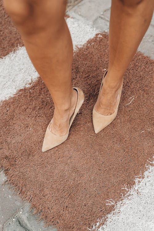 Woman in stylish high heels on mat