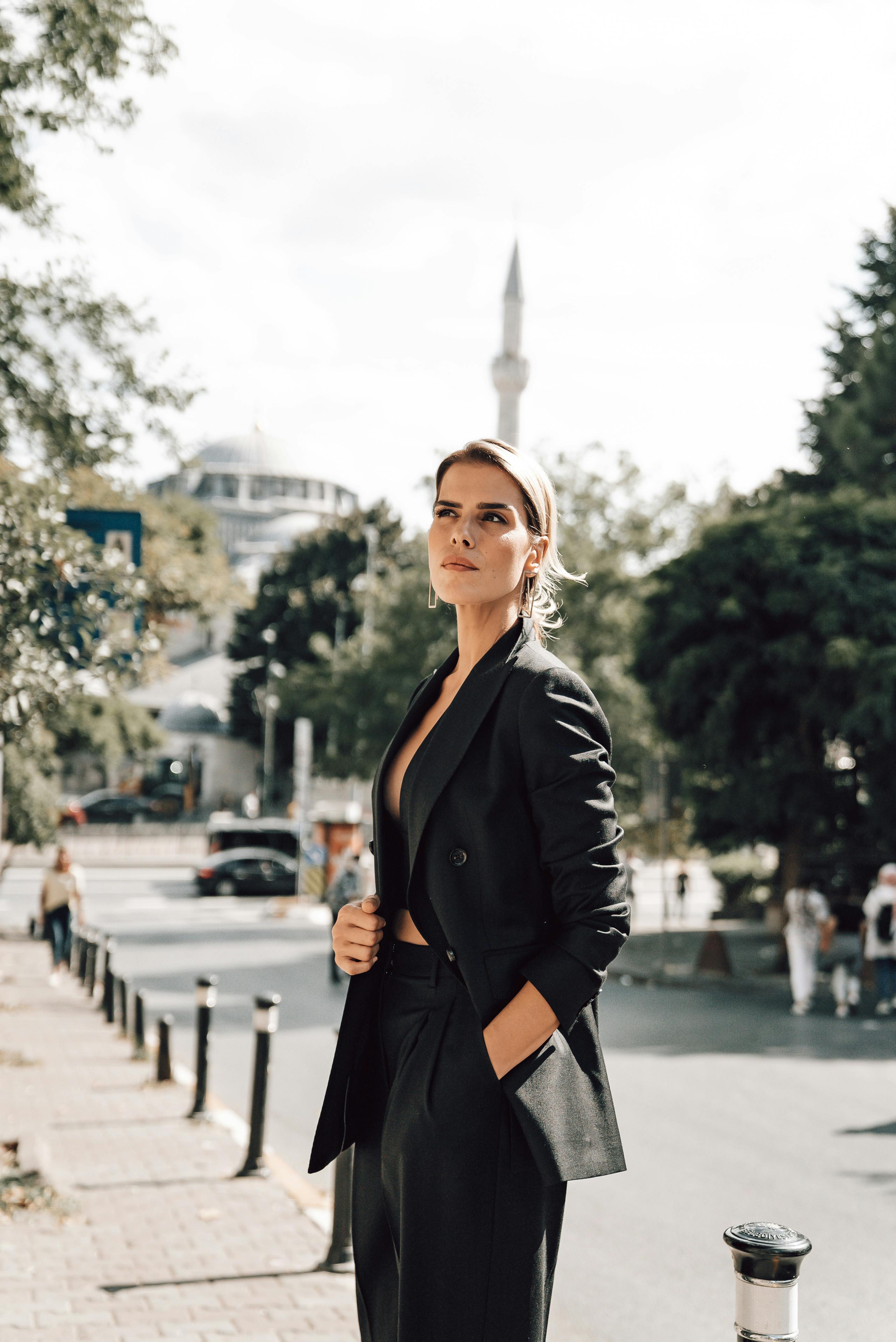 elegant woman in formal suit standing on sidewalk