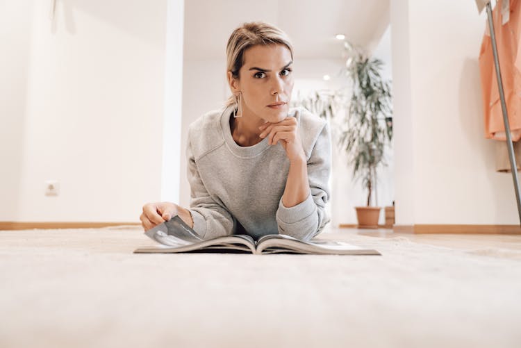 Focused Woman Reading News In Magazine