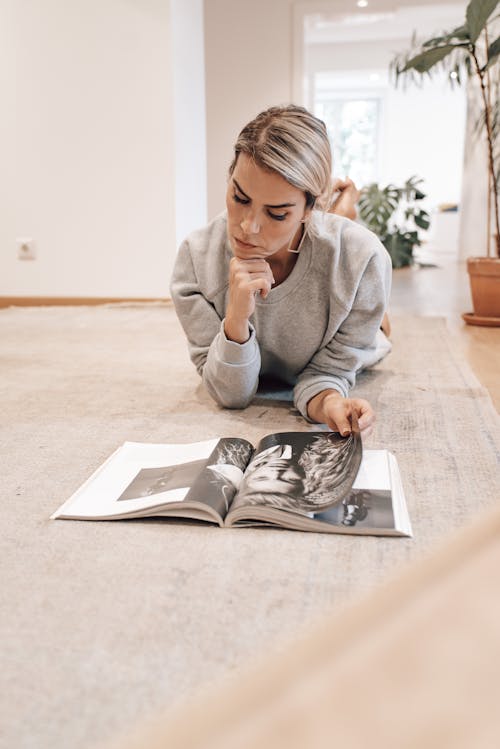 Smart woman reading magazine while resting at home