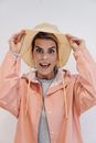 Adult astonished female in casual jacket looking at camera with open mouth and surprised gaze in daylight