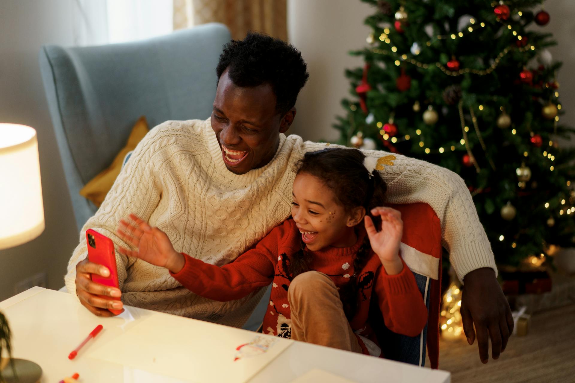 Dad and Daughter Having Fun and Laughing While Looking at the Smartphone