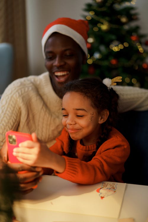 Free Dad and Daughter Taking Selfie Using a Smartphone Stock Photo