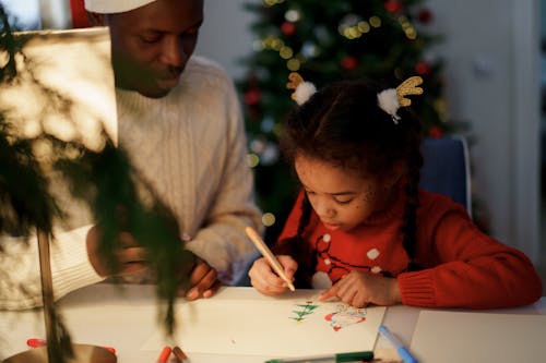 Free Dad Watching Her Daughter Draw a Christmas Tree Stock Photo