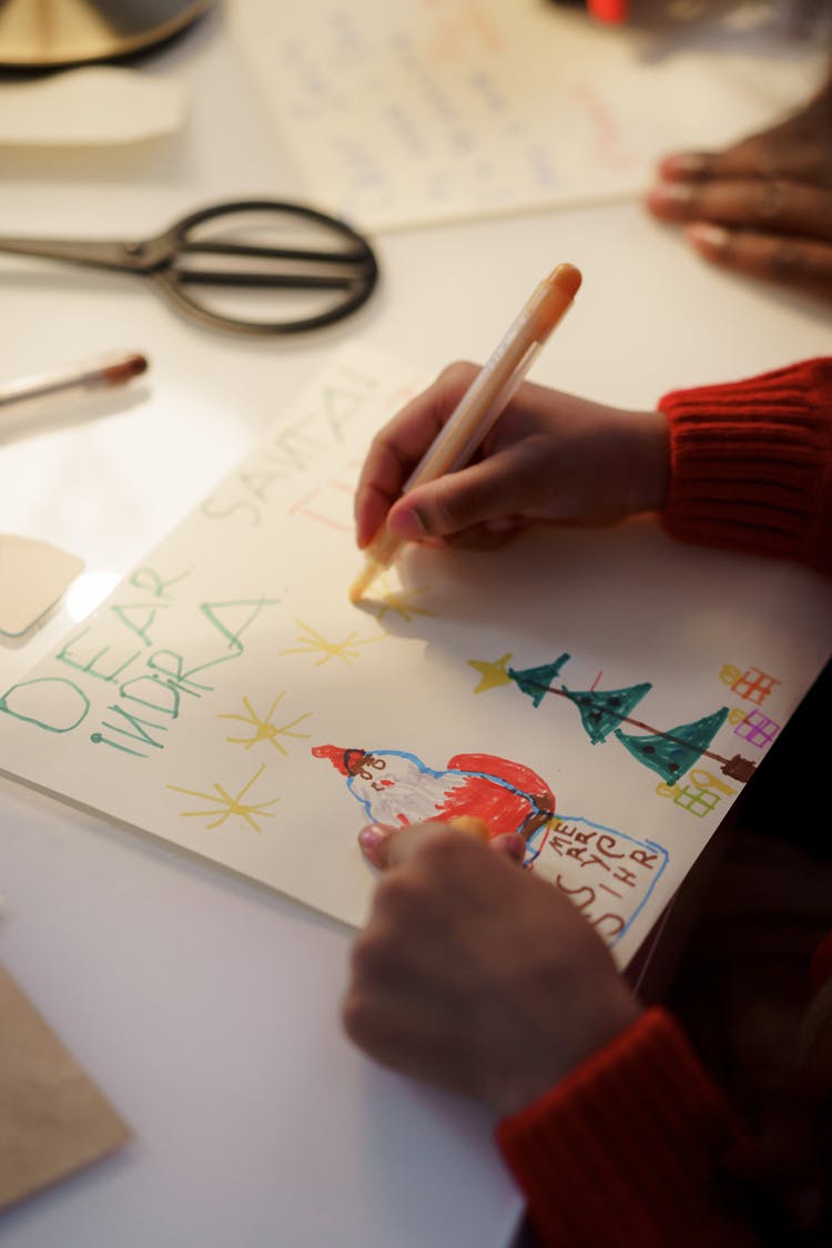 A Person In Red Sweater Making A Christmas Letter