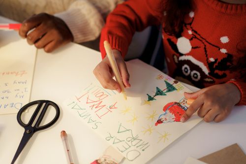 Free Children crafting heartfelt letters to Santa, full of creativity and holiday cheer. Stock Photo