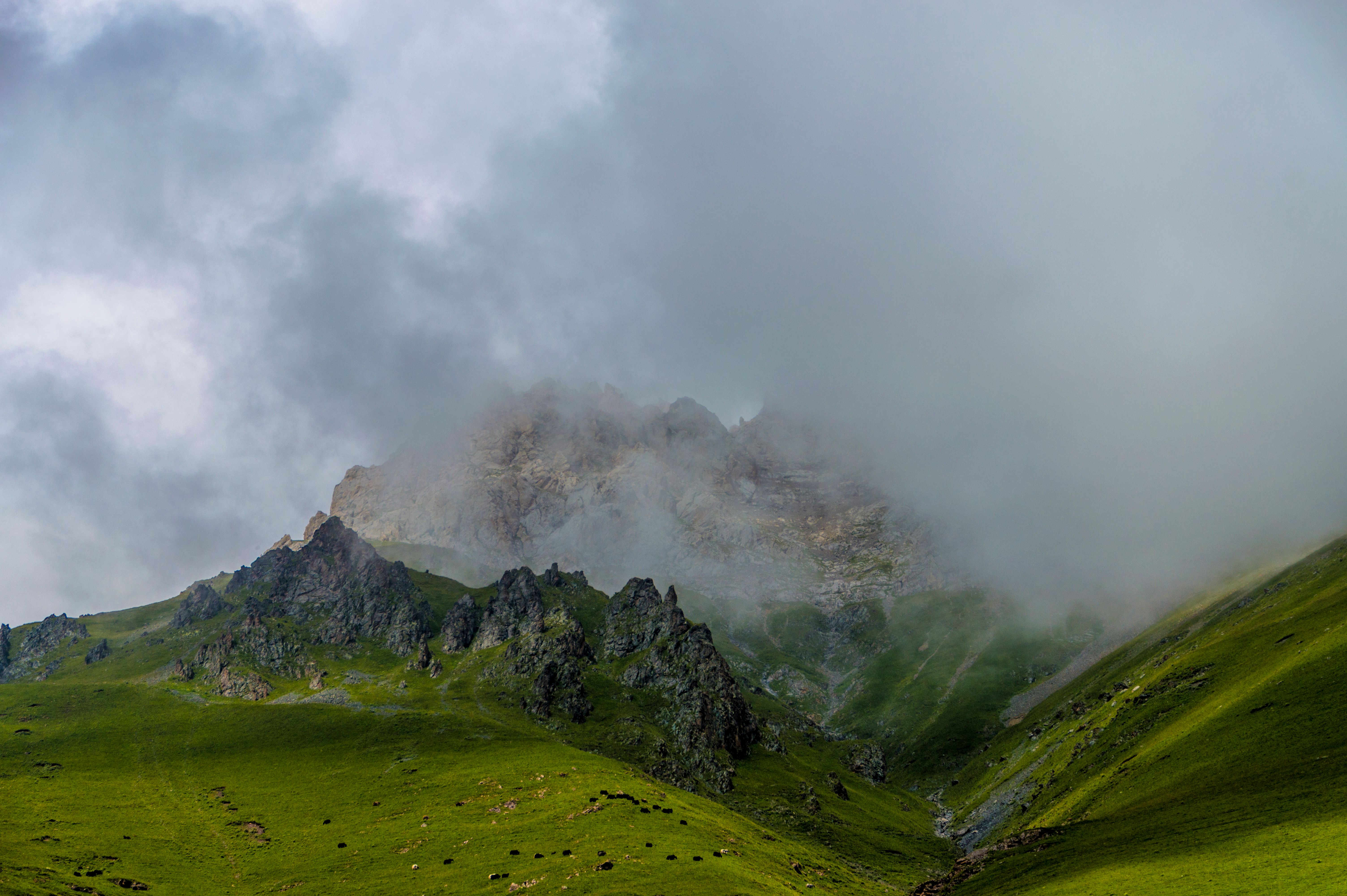 View of a Dark Rocky Mountain under a Cloudy Sky · Free Stock Photo