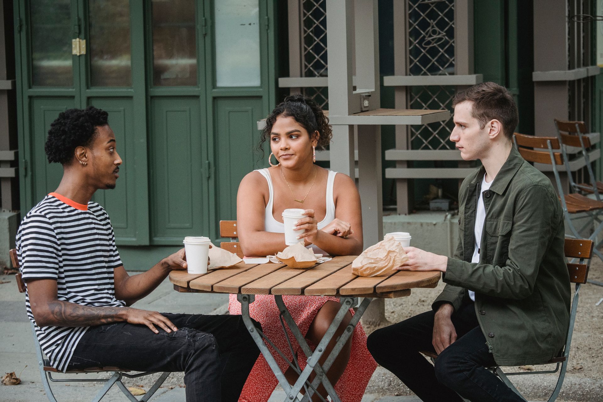 Three people talking together at a café table