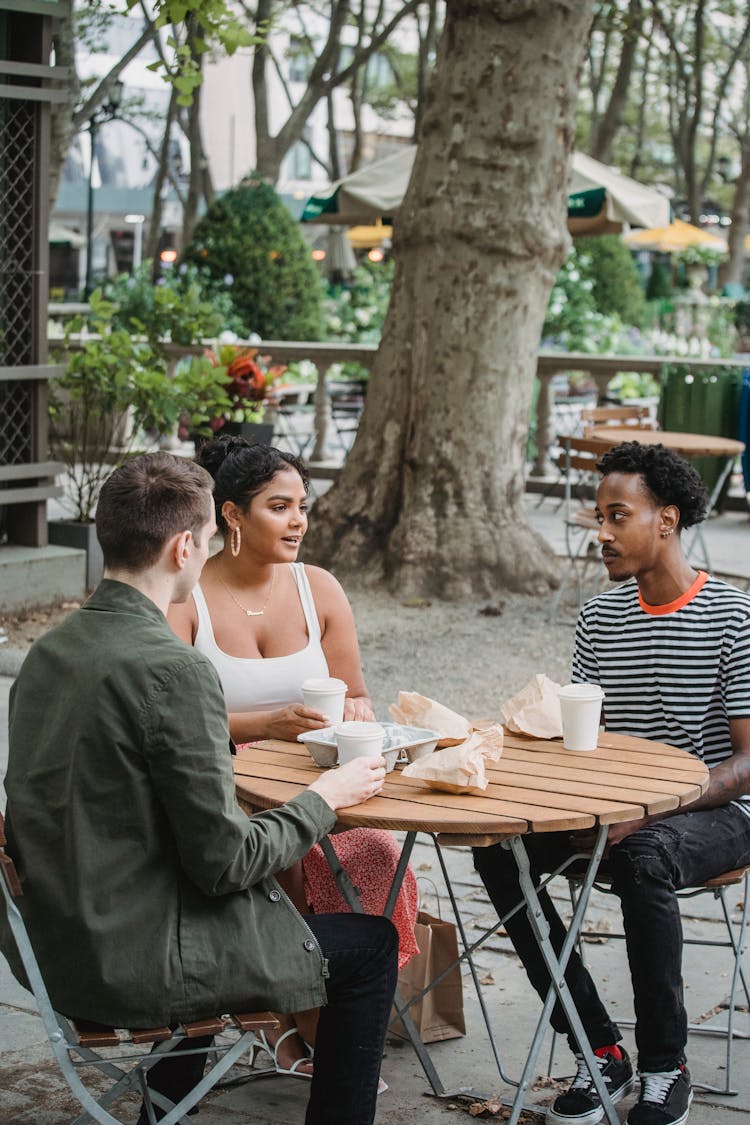 Young Diverse Teenagers Having Lunch In Outdoor Cafe