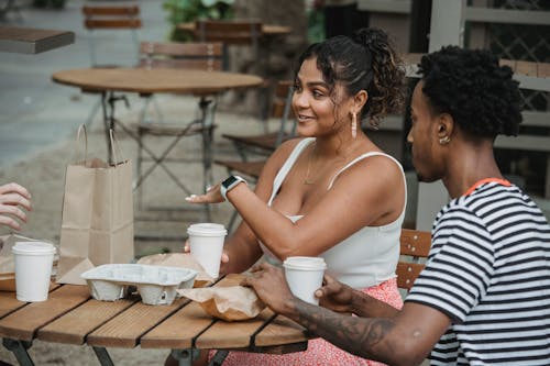 Free Cheerful diverse colleagues having coffee break in cafe and discussing work Stock Photo