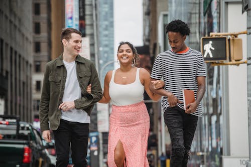 Free Cheerful diverse students smiling and crossing road in city district Stock Photo