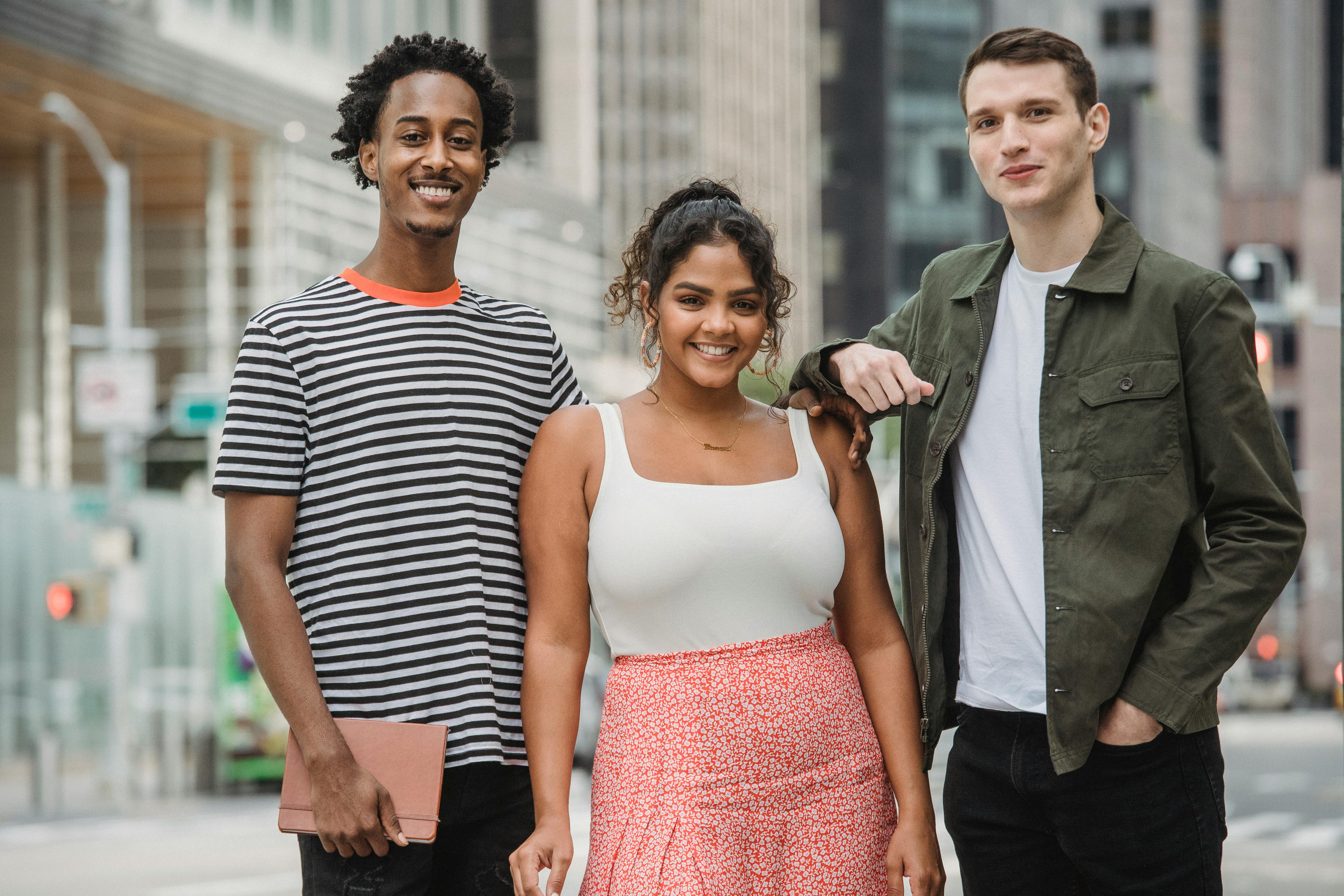 happy diverse teenagers chilling together on city street