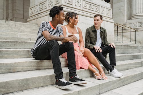Free Content multiethnic friends sitting on stairs Stock Photo
