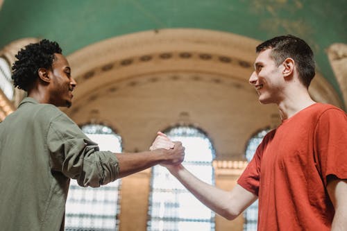 Free Smiling multiracial friends greeting each other in hallway Stock Photo