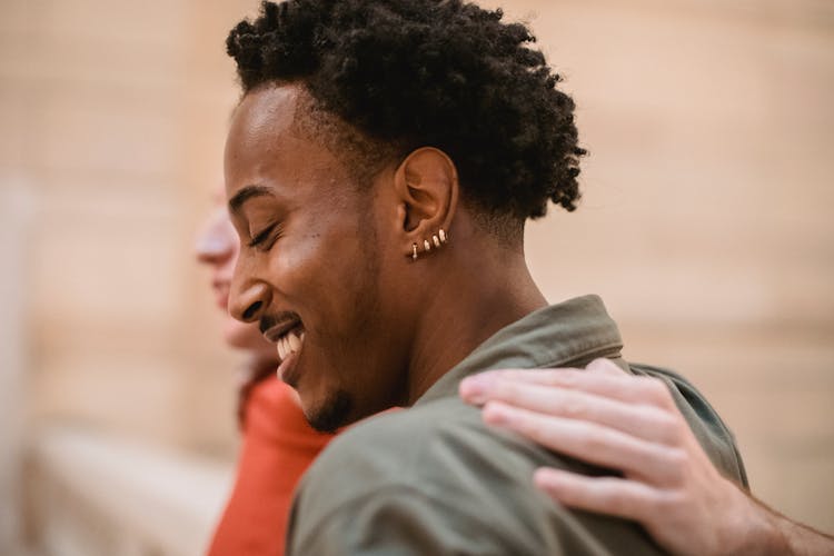 Smiling Black Man Hugging With Anonymous Friend