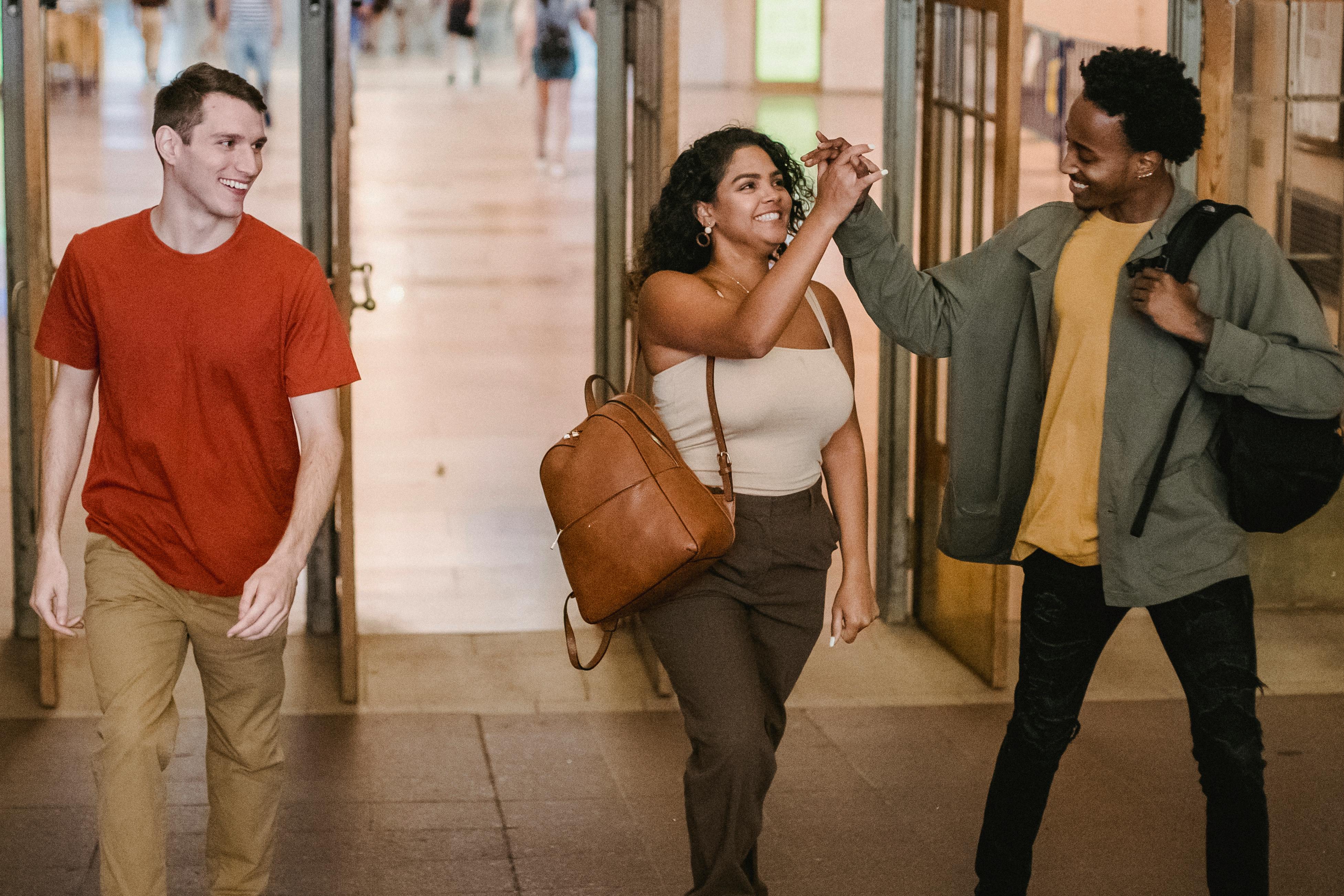 cheerful multiethnic friends walking in campus