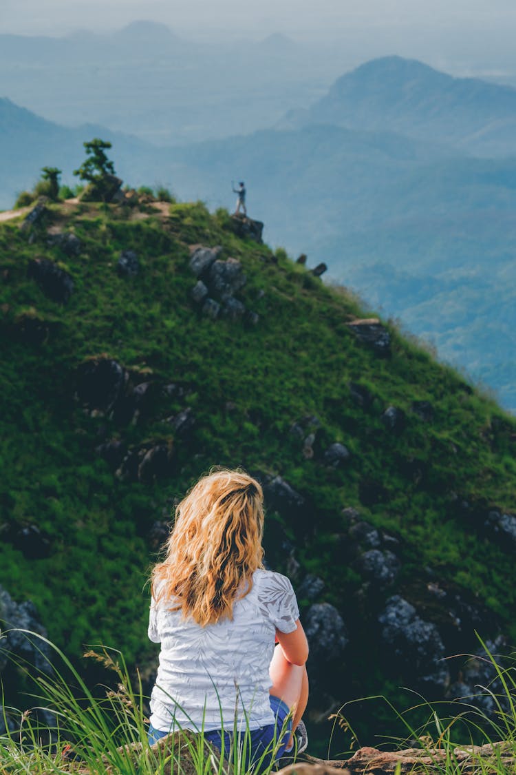 Woman Wearing A White Shirt  Sitting On Mountain Top