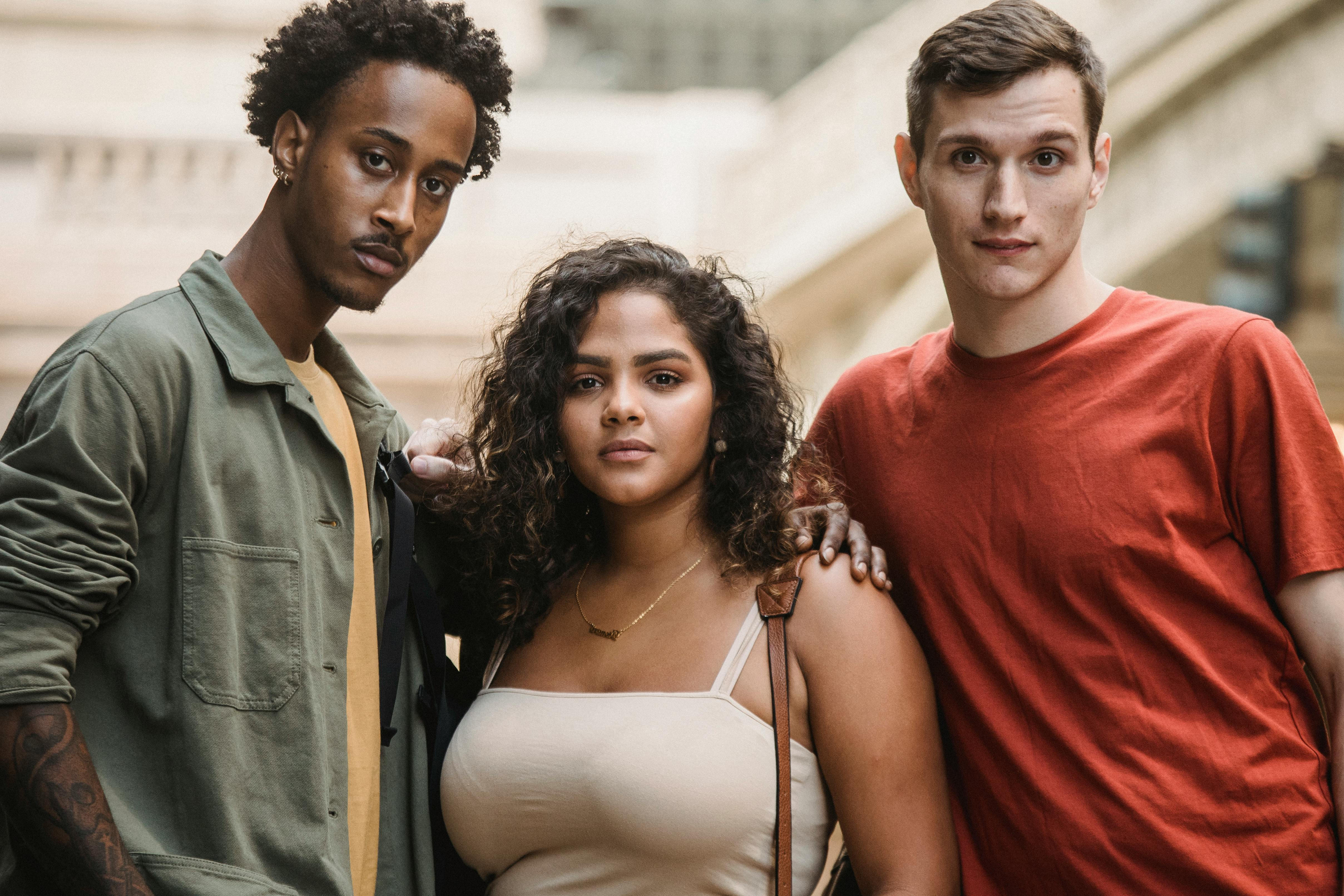 calm diverse men and ethnic woman looking at camera while standing together