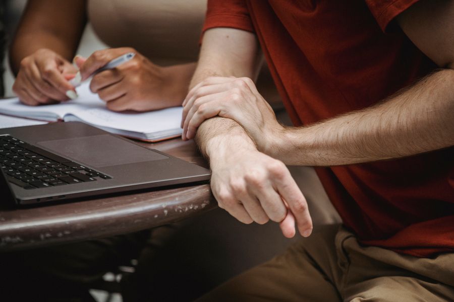 Two students using a laptop and notebooks while preparing for an examination