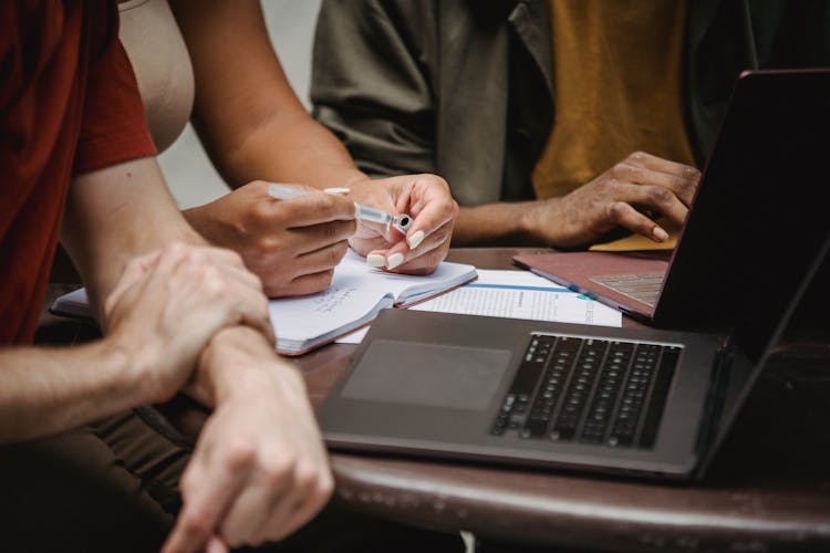 Crop Multiethnic Friends Working On Startup Using Laptops In Office