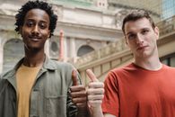 Positive young multiracial guys demonstrating thumbs up sign at camera