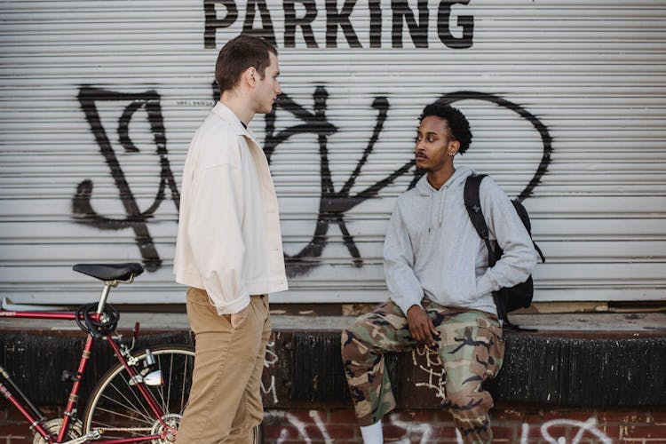 Pensive Young Diverse Guys Chilling And Chatting On Street